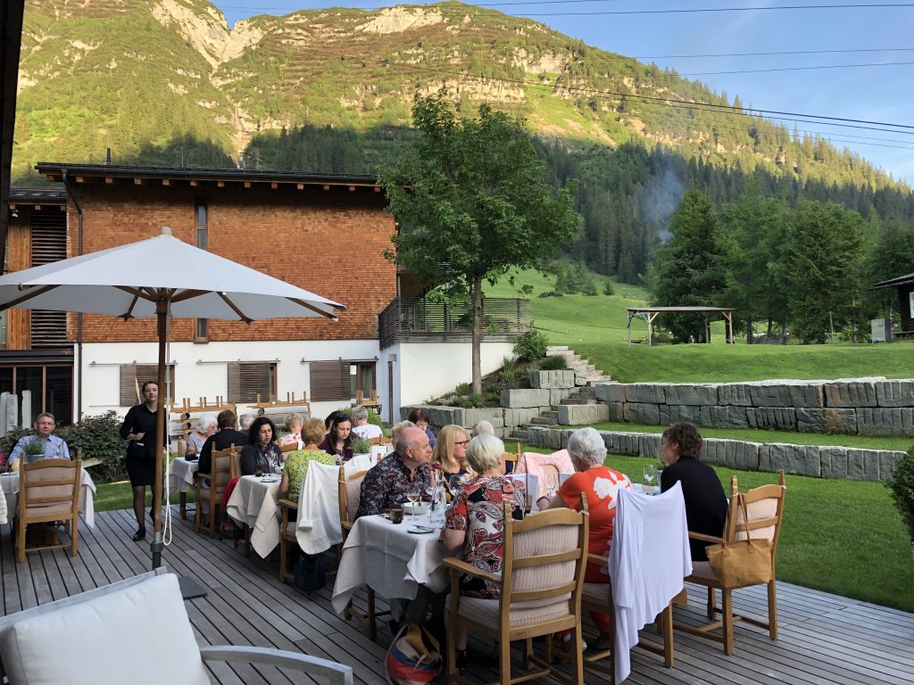 View of the dining terrace at Der Berghof Hotel during dinner beside a mountain