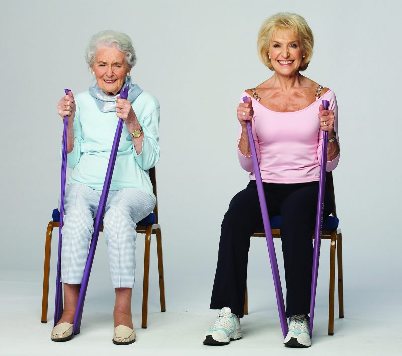 Rosemary Conley and her elderly Mother in Law seated, demonstrating an exercise with a toning band