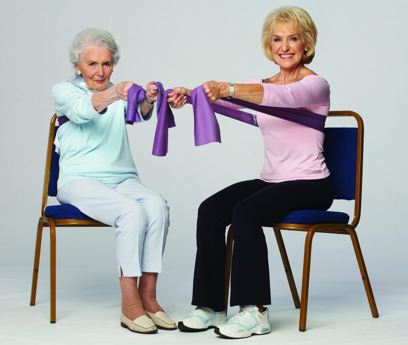 Rosemary Conley and her elderly Mother in Law seated, demonstrating an exercise with a toning band