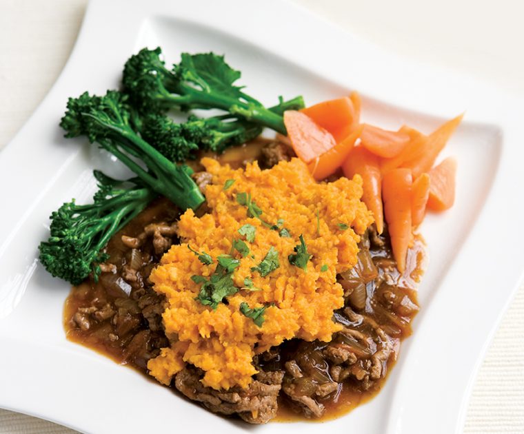 A plate of Cottage Pie with broccoli and carrots