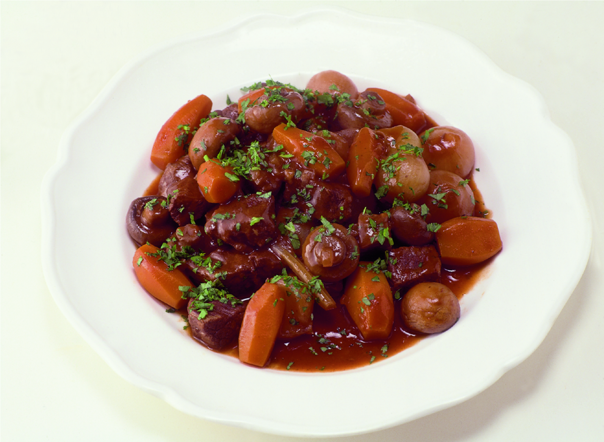 Plate of Beef Bouguignon with beef, carrots, mushrooms and celery in a tomato based gravy sprinkled with fresh thyme