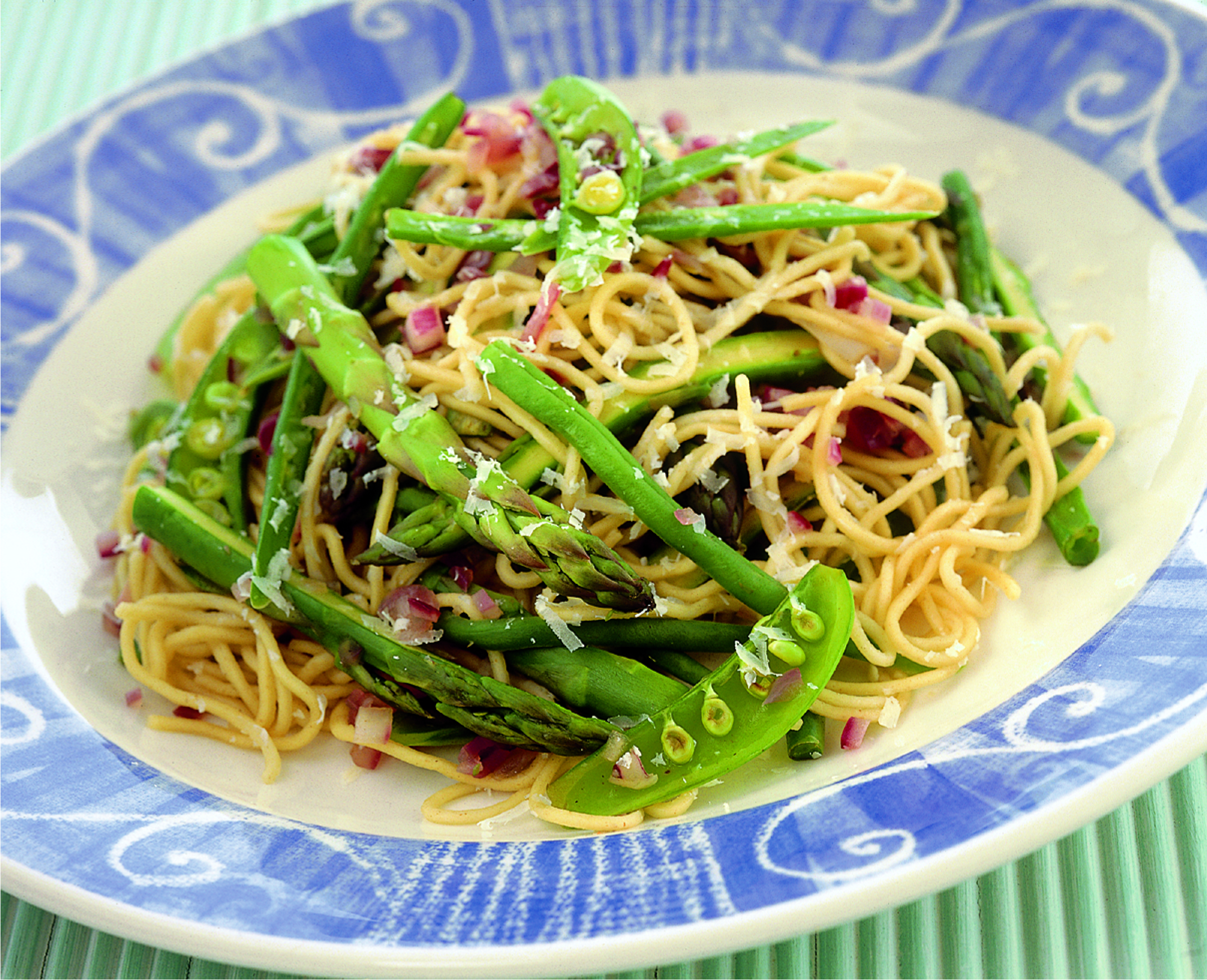 Plate of noodles mixed with green beans, asparagus and pea-pods