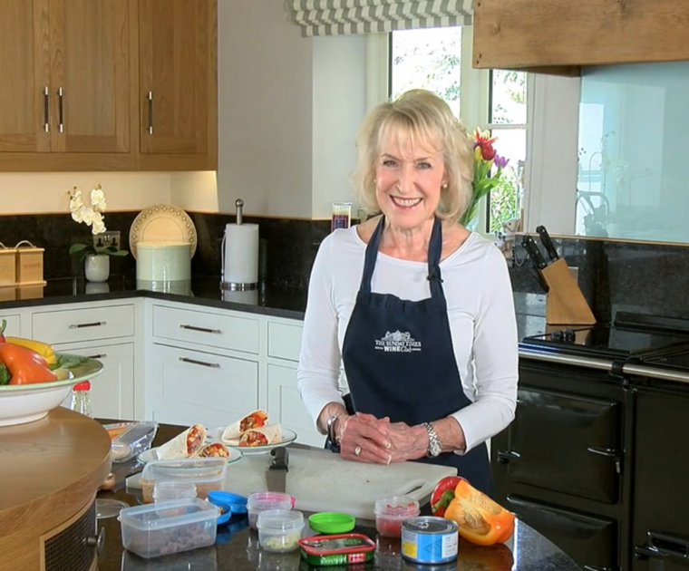 Rosemary Conley standing in front of the worktop in her kitchen with various ingredients