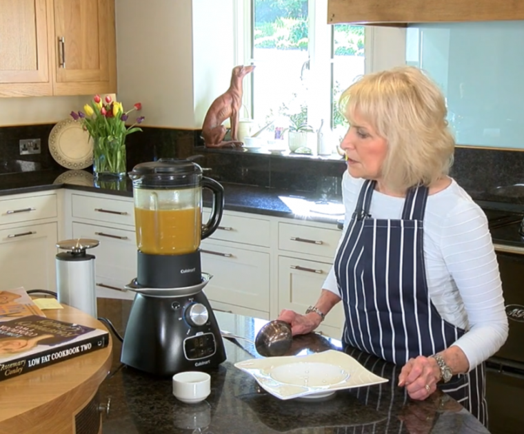 Rosemary Conley in her kitchen looking at a soup mixer full of Butternut Squash soup