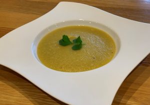 Curried Parsnip Soup in a white bowl garnished with corriander