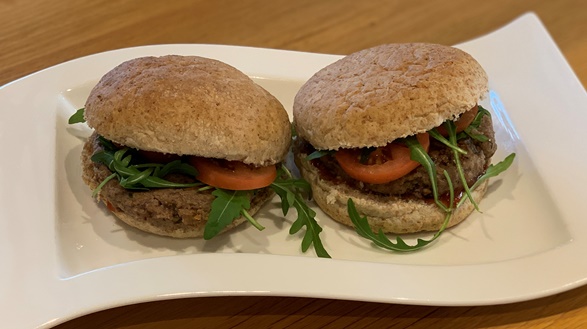 Two Super-sonic Beefburgers in wholemeal bwon baps with rocket and tomato garnish