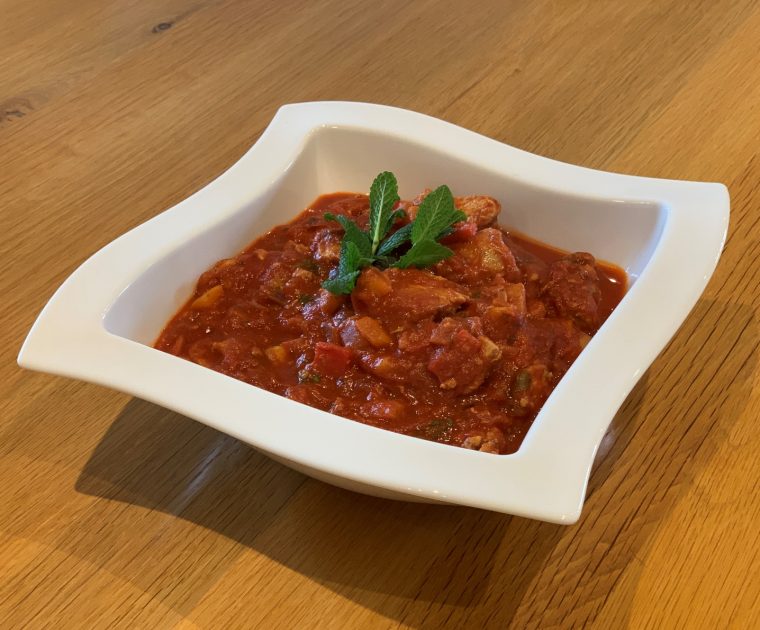 Chicken Jalfrezi in a white square dish garnished with mint