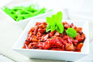Aubergine Tagine in a square bowl topped with flat-leaf parsley