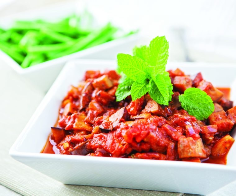 Aubergine Tagine in a square bowl topped with flat-leaf parsley