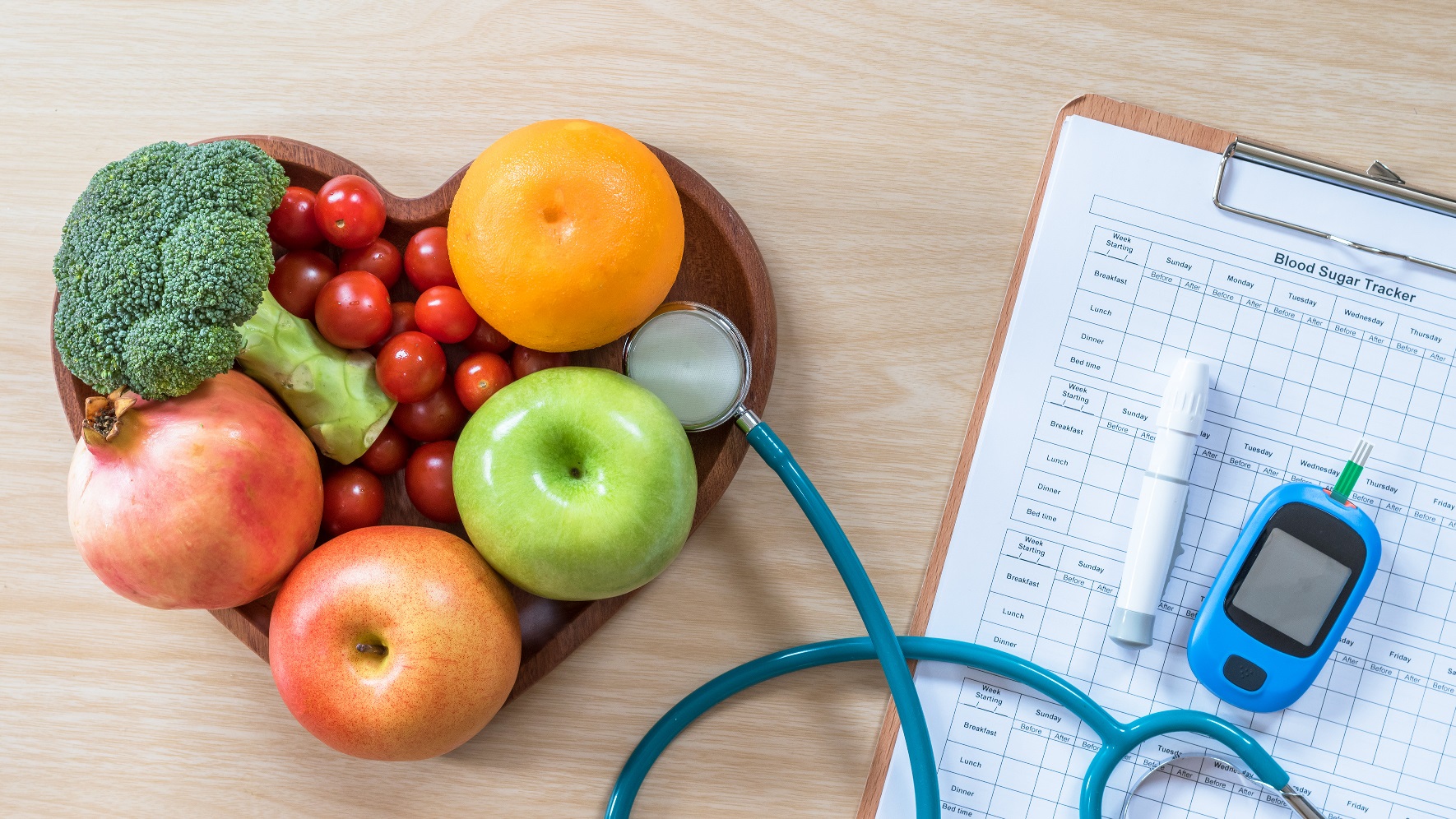 Type 2 diabetes image including a heart shaped bowl of healthy fruit and vegetables, a stethascope, blood glucose monitor and a medical chart