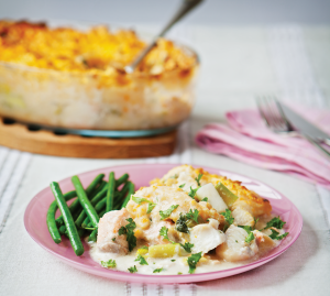 A creamy fish pie topped with mash and served with green beans