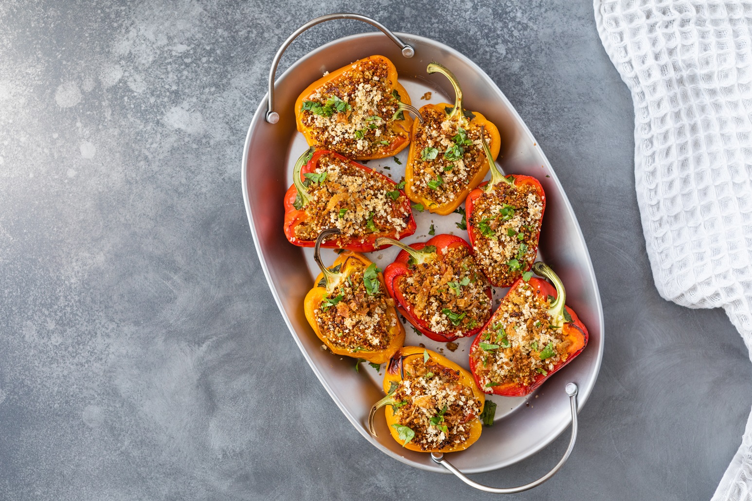 Red and yellow peppers halved and stuffed with tomatoes, sardines and garlic