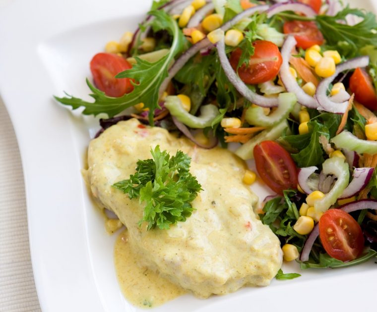 Posrk steak smothered in a spicy yogurt sauce served with a salad