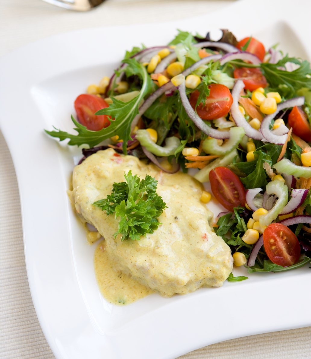 Posrk steak smothered in a spicy yogurt sauce served with a salad