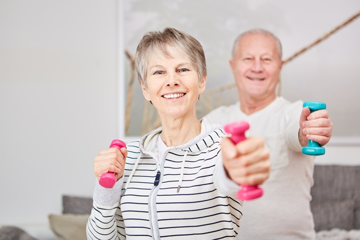 A senior couple exercising together making punching movements with hand weights