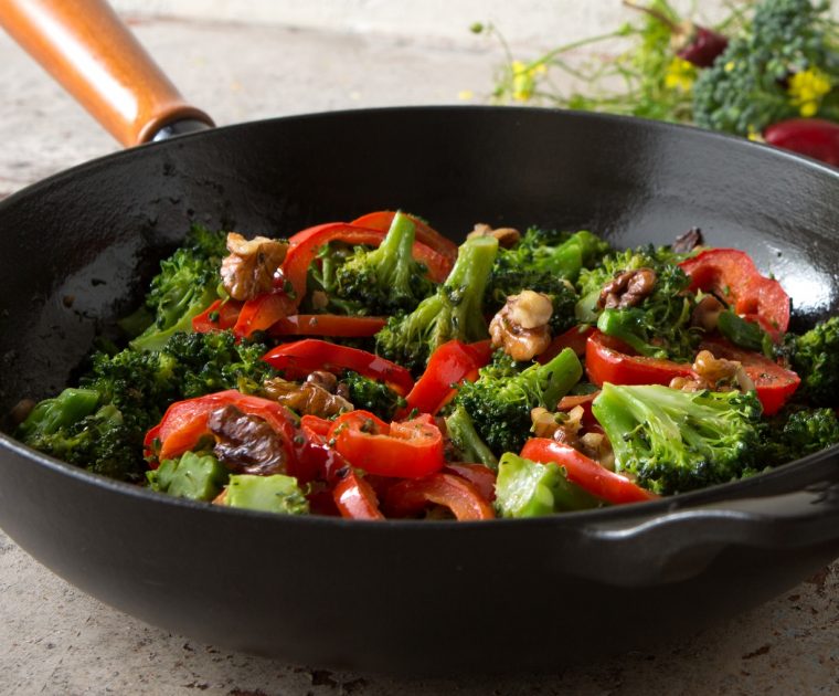 A frying pan with broccoli and red pepper stir fry