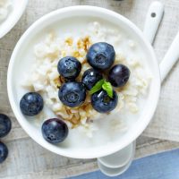 A bowl of rice pudding topped with blueberries